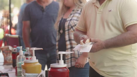 Man-buying-hot-dog-from-street-fair-vendor