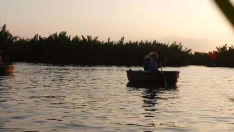 People-On-Basket-Boats-Floating-On-The-Calm-Water-On-Sunset-In-Tam-Coc,-Vietnam