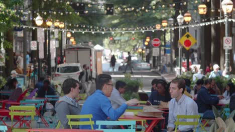 Una-Toma-Panorámica-De-Una-Multitud-Diversa-De-Jóvenes-Profesionales-Almuerzan,-Se-Relajan-A-La-Sombra-Y-Conversan-Mientras-Caminan-Por-El-Centro-Histórico-De-Atlanta-Durante-El-Almuerzo-En-Un-Ajetreado-Día-De-Trabajo-De-Verano