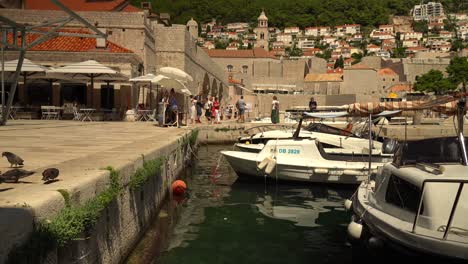 El-Puerto-Al-Este-Del-Casco-Antiguo-De-Dubrovnik,-Croacia,-Y-Algunos-Turistas-Paseando-Por