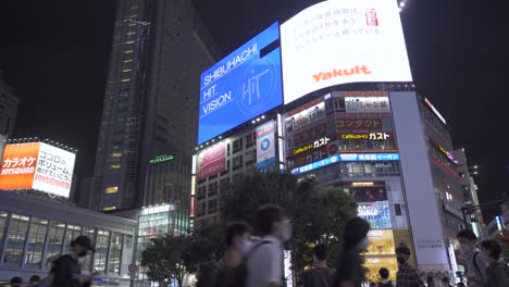 Punto-De-Vista-De-Lado-Caminando-A-Través-De-Shibuya-Scramble-Ocupado-En-La-Noche---Vista-De-ángulo-Bajo-Hacia-Arriba