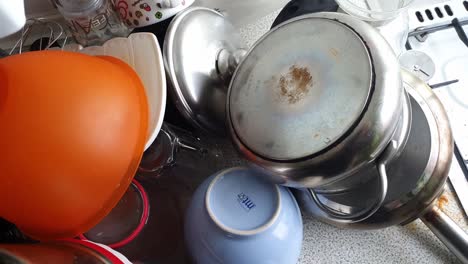 pile-of-washed-Dishes-On-A-Sink-Drainer