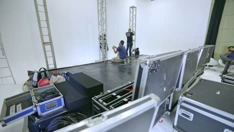 Toma-De-Seguimiento-Orbital-De-Un-Equipo-Montando-Un-Escenario-En-Un-Estudio-De-Transmisión