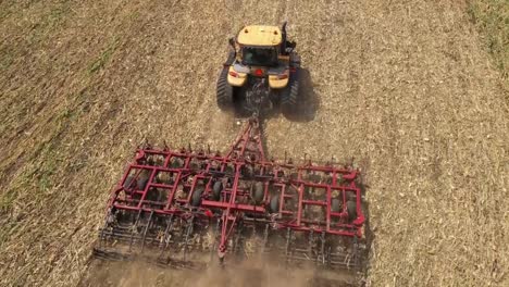 DRONE-SHOT-FOLLOWS-A-DISC-HARROW-DISKING-A-FIELD