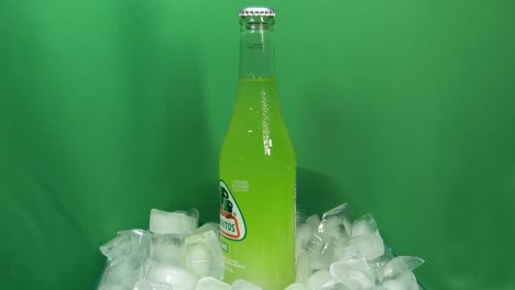 3-3-Jarritos-Limettengetränkeflasche,-Die-Sich-Um-360-Grad-Dreht,-Auf-Gestapeltem-Eis-Vor-Einem-Grünen-Bildschirm