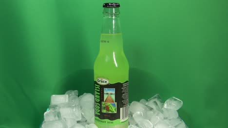 3-3-Grace-Brand-Aromatisierte-Grapefruitgetränk-Glasflasche,-Die-Sich-Um-360-Grad-In-Einer-Mit-Eis-Gefüllten-Schüssel-Vor-Einem-Grünen-Bildschirm-Dreht