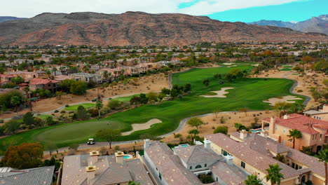 Vista-Aérea-Del-Campo-De-Golf-Suburbios-Del-Sudoeste-Con-Montañas-En-El-Fondo-Cerca-De-Roca-Roja