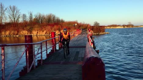 Handgehaltene-Schwebende-Brückenaufnahme-Mit-Sich-Näherndem-Radfahrer,-Der-Den-Rahmen-überquert