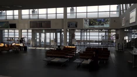 POV-on-escalator-riding-up-with-passing-view-of-waiting-room-in-Japan