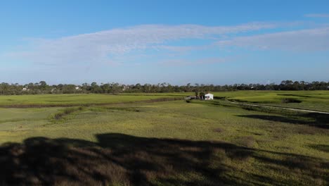 Vuelo-Aéreo-Hacia-Una-Pequeña-Casa-Aislada-En-El-Pantano-Con-Un-Pequeño-Bote-En-Tybee-Island-Georgia