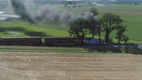 Luftaufnahme-Eines-Thomas-The-Tank-Engine-Mit-Passagierwagen,-Die-Entlang-Der-Amischen-Landschaft-Schnaufen