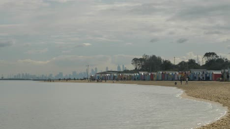 Tourists-walking-and-taking-photo-at-Brighton-Bathing-Boxes,-Melbourne,-Australia