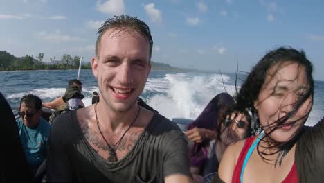 People-enjoying-a-ride-on-a-boat-racing-across-the-ocean-are-sprayed-by-sea-water-as-the-speedboat-bounces-on-the-waves