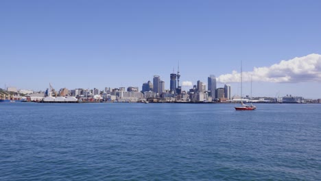 Toma-Panorámica-Amplia-Y-Lenta-Del-Horizonte-De-La-Ciudad-De-Auckland-Y-La-Bahía-Comercial,-Incluido-El-Paso-De-Veleros,-Auckland,-Nueva-Zelanda