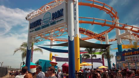 Pacific-Park-amusement-park-entrance-with-rollercoaster-going-by-in-the-background