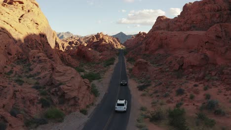 Einschub-Aus-Der-Luft-Auf-Einen-Rolls-Royce-Und-Einen-Ferrari,-Die-Auf-Einer-Offenen-Autobahn-Im-Valley-Of-Fire,-Nevada,-Fahren