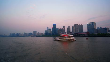 Sightseeing-boat-takes-tourists-on-an-evening-tour-of-Shanghai's-famed-Huangpu-River-boasting-spectacular-lights-of-nearby-commercial-buildings