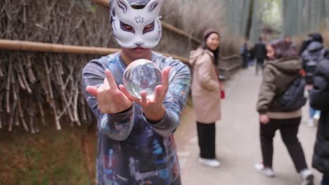 Mago-Enmascarado-Realizando-Un-Truco-De-Magia-En-El-Bosque-De-Bambú-De-Arashiyama-En-Kyoto,-Japón