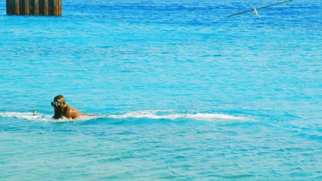 Hombre-Montando-Un-Scooter-Seabob-Y-Saltando-Sobre-La-Superficie-Del-Océano-Azul-Turquesa-En-Willemstad,-Curacao