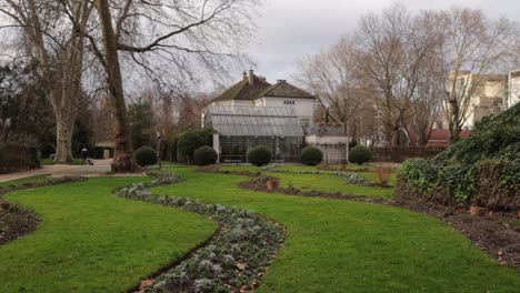 Maison-du-jardinage-building-in-Bercy-park-in-Paris-during-overcast-day,-truck-right-wide-shot