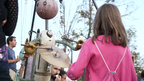 Una-Niña-Jugando-Con-Una-Marioneta-Hecha-De-Materiales-Reciclados-Durante-El-Festival-De-La-Merce-En-Barcelona---ángulo-Bajo