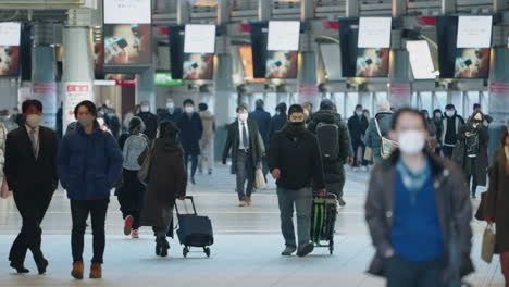 Eine-Vielzahl-Japanischer-Einheimischer,-Die-Im-Winter-Inmitten-Einer-Pandemie-In-Tokio,-Japan,-Zur-Arbeit-Gehen-Und-Am-Bahnhof-Shinagawa-Spazieren-Gehen