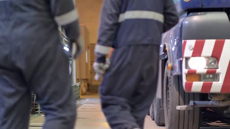 Workers-waiting-for-high-load-truck-to-park-in-factory