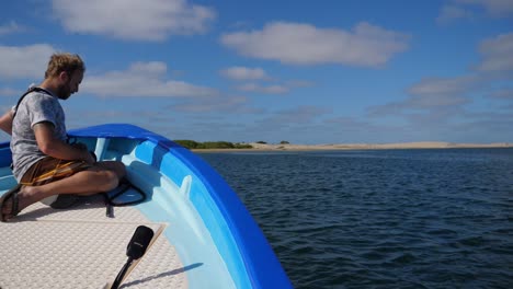 Eröffnungsaufnahme,-Kameramann-Sitzt-Auf-Dem-Deck-Des-Bootes,-Im-Hintergrund-Malerischer-Blick-Auf-Die-Küstenbucht-Von-Adolfo-Lopez-Mateos-Baja-California-Sur,-Mexiko