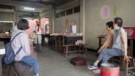 Few-followers-gathering-watching-Taiwanese-male-faith-ritual-worship-performance-in-Taiwan-temple