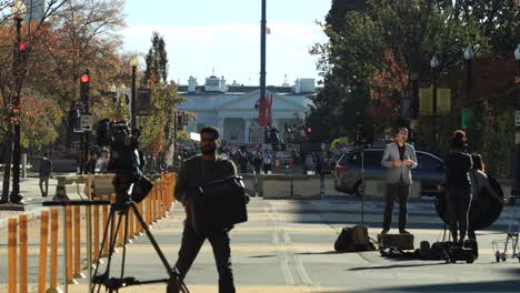 News-reporter-speaks-in-front-of-White-House-and-Biden-supporters-in-background