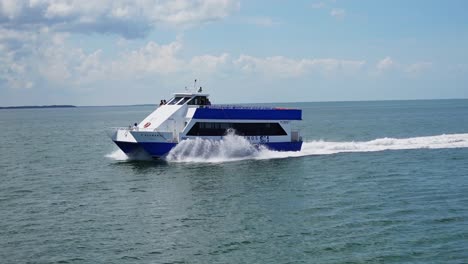 Einspielaufnahme,-Touristenboot-Fährt-Am-Blauen-Meer-Der-Insel-Holbox,-Mexiko-Vorbei,-Im-Hintergrund-Bewölkter-Himmel