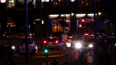 Vehículo-De-La-Policía-Del-Reino-Unido-Conduciendo-A-Través-De-Los-Semáforos-Por-La-Noche-En-El-Ajetreado-Cruce-Del-Centro-De-La-Ciudad