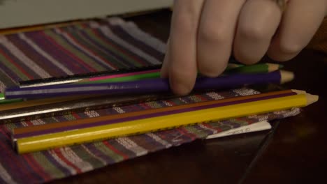 Girl-wearing-a-ring-picking-up-a-coloring-pencil-to-draw-a-picture-of-flowers