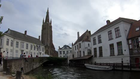 Día-Nublado-En-Brujas-Con-Algunos-Edificios-Tradicionales-Europeos-Y-La-Iglesia-De-Nuestra-Señora-Al-Fondo,-Bélgica