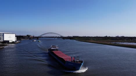 Wilson-Waal-Barcaza-Navegando-A-Través-Del-Río-Noord-Con-Puente-En-El-Fondo-En-Hendrik-ido-ambacht,-Países-Bajos