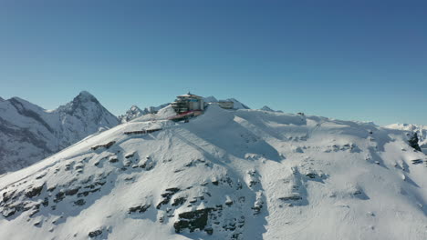 Volando-Hacia-El-Centro-De-Esquí-En-La-Cima-De-Una-Montaña-Cubierta-De-Nieve