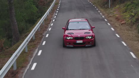 Red-Luxury-Car-Travel-On-Asphalt-Road-Near-Barcelona,-Spain-During-Daytime