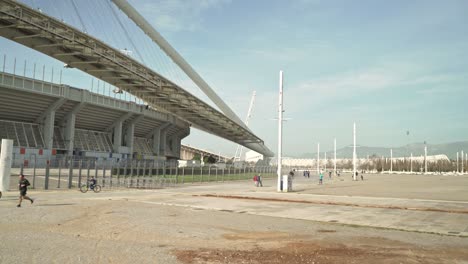 Pan-wide-view-of-Athens-Olympic-stadium,-people-having-fun,-during-coronavirus-lockdown-restrictions