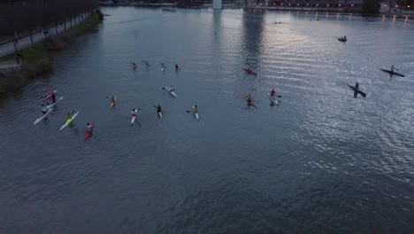 Slow-Motion-Tilt-Down,-Group-of-Kayakers-on-River-in-Seville,-Spain