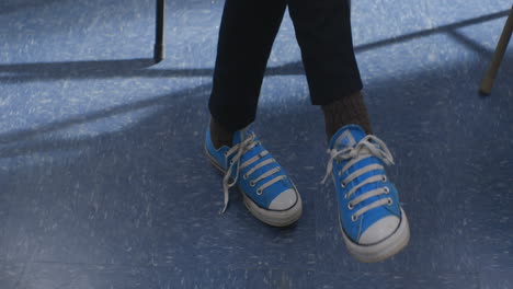 Teenager-Taps-Foot-Anxiously-Impatient-in-Classroom-Setting,-Close-Up