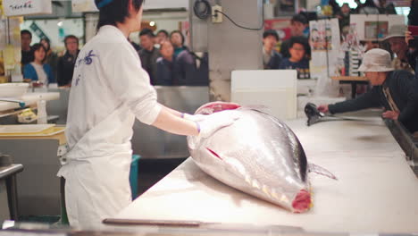 Un-Carnicero-Para-Cortar-La-Cabeza-De-Un-Gran-Atún-Rojo-Frente-A-Los-Japoneses-En-El-Mercado-De-Pescado-Toretor-Ichiba-En-Wakayama,-Japón---Tiro-Medio