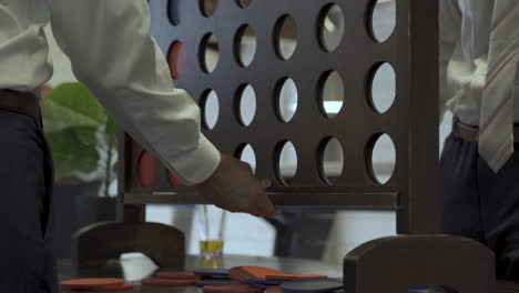 Two-men-reset-game-of-connect-four-at-wedding-party