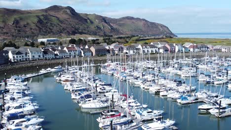 Yates-De-Lujo-Y-Veleros-Amarrados-En-Conwy-Marina-Mountain-Waterfront-Vista-Aérea-Norte-De-Gales-Inclinar-Hacia-Arriba-A-La-Derecha