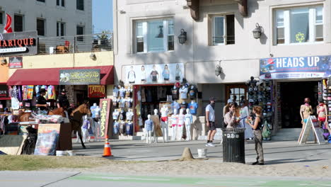 Lapd-A-Caballo-Caminando-Por-El-Paseo-Marítimo-De-Venice-California-En-Un-Día-Soleado,-Peatones-Caminando-Y-Paseando-Por-Los-Escaparates