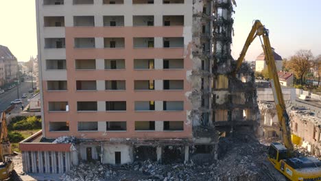 Drone-view-of-an-Excavator-with-a-long-boom-demolishing-a-high-rise-building