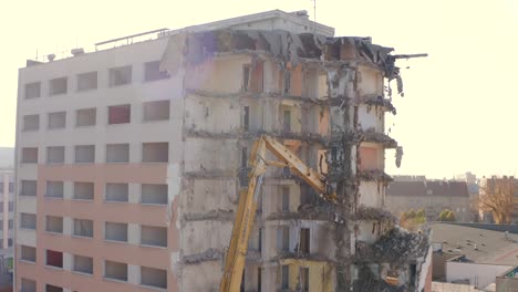 Vista-De-Una-Excavadora-Con-Una-Pluma-Larga-Demoliendo-Un-Edificio-De-Gran-Altura