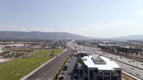 Cars-Travelling-At-The-I-15-Freeway-In-The-City-Of-Draper,-Utah-On-A-Fair-Weather---ascending-aerial-drone-shot