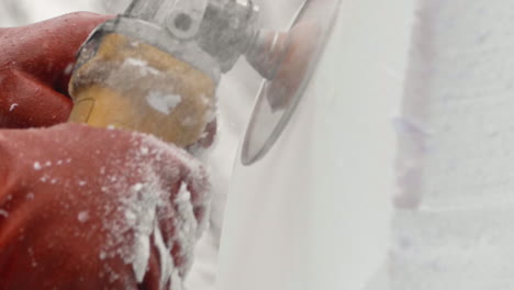 Extreme-close-up-of-Dewalt-angle-grinder-shaving-away-ice-blocks,-Slow-Motion