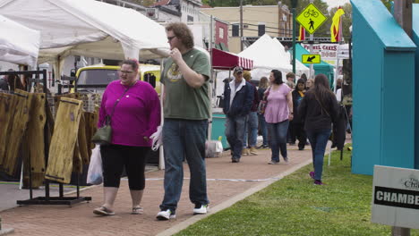 People-stroll-on-a-promenade-during-Dogwood-Festival,-Siloam-Springs,-Arkansas