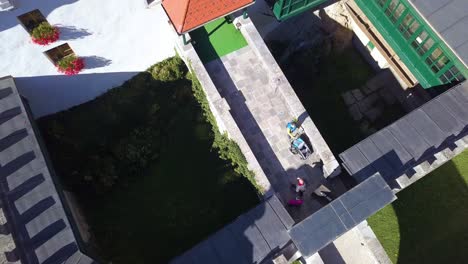 Couple-Walking-Over-Bridge-To-Visit-Grad-Sneznik-White-Medieval-Castle